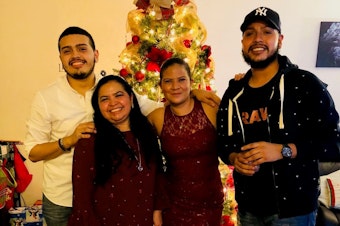 caption: Javier Maradiaga (far right) with his brother, Jason Castillo; mother, Alma Maradiaga; and sister, Dariela Moncada on Christmas Eve in 2017.