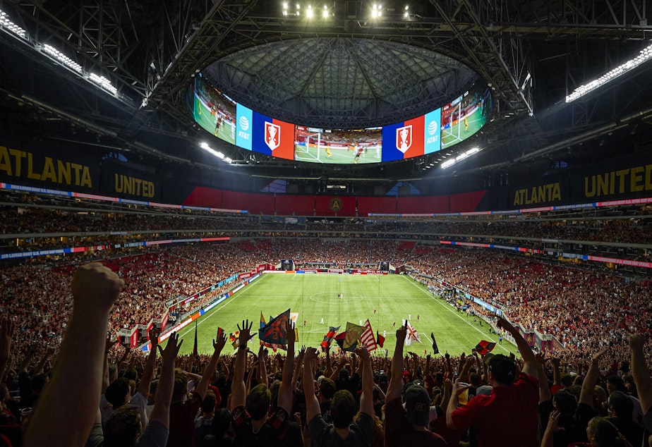 caption: Fans of the MLS' Atlanta United wave banners at Mercedes-Benz Stadium in Atlanta, a venue selected for matches in the 2026 World Cup.