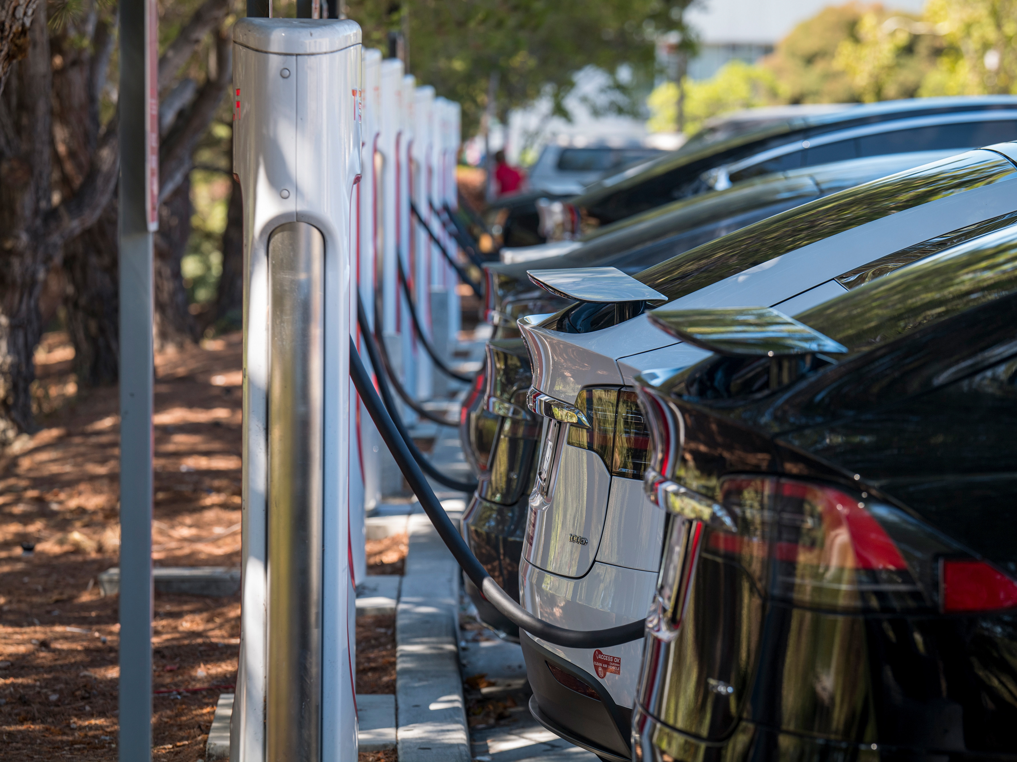 caption: Electric vehicles at a charging station last year in San Mateo, Calif. The governors of 12 states, including California, have called on President Biden to order that all cars and light trucks sold in the U.S. after 2035 be zero-emission vehicles.