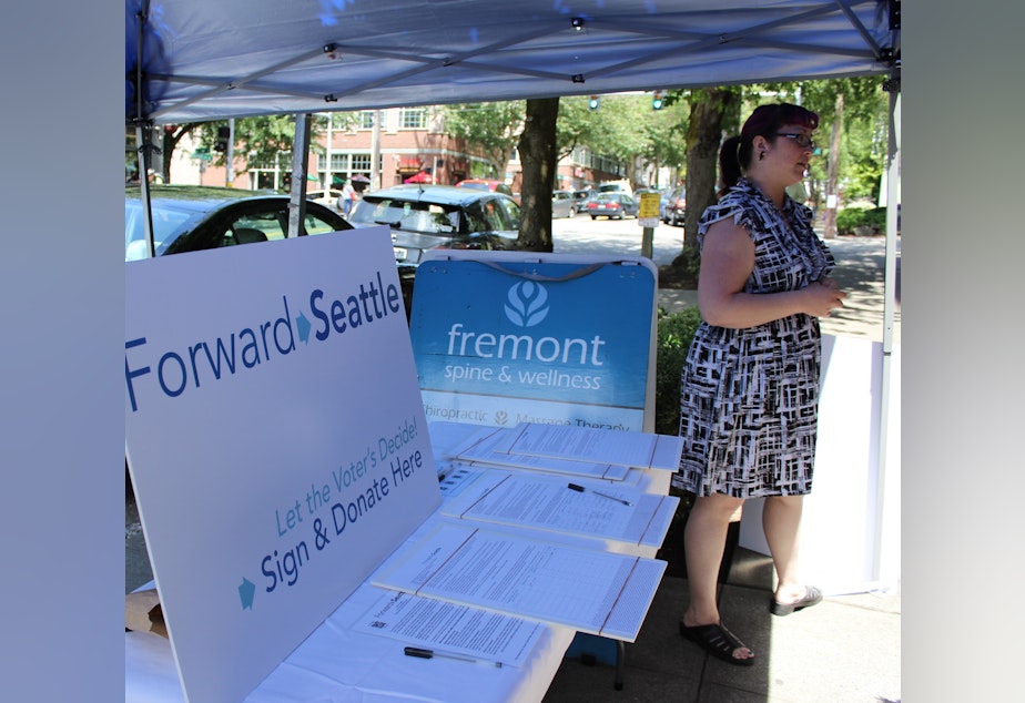 caption: Forward Seattle co-chair Kathrina Tugadi collecting signatures at the recent Fremont Fair