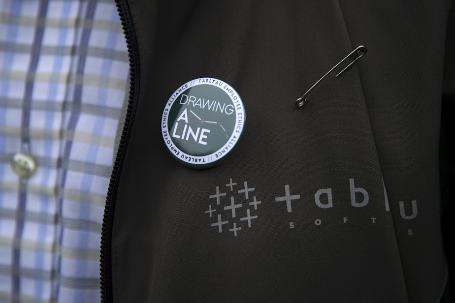 caption: James Baker wears a 'Drawing A Line' pin on Wednesday, December 4, 2019, in Seattle.