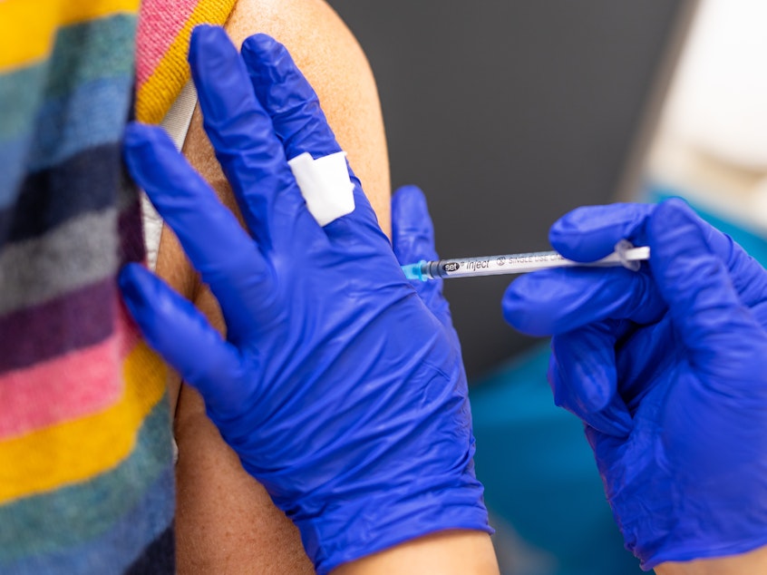 caption: A vaccination center worker inoculates a woman with the Biontech vaccine against Covid-19 in Lower Saxony.