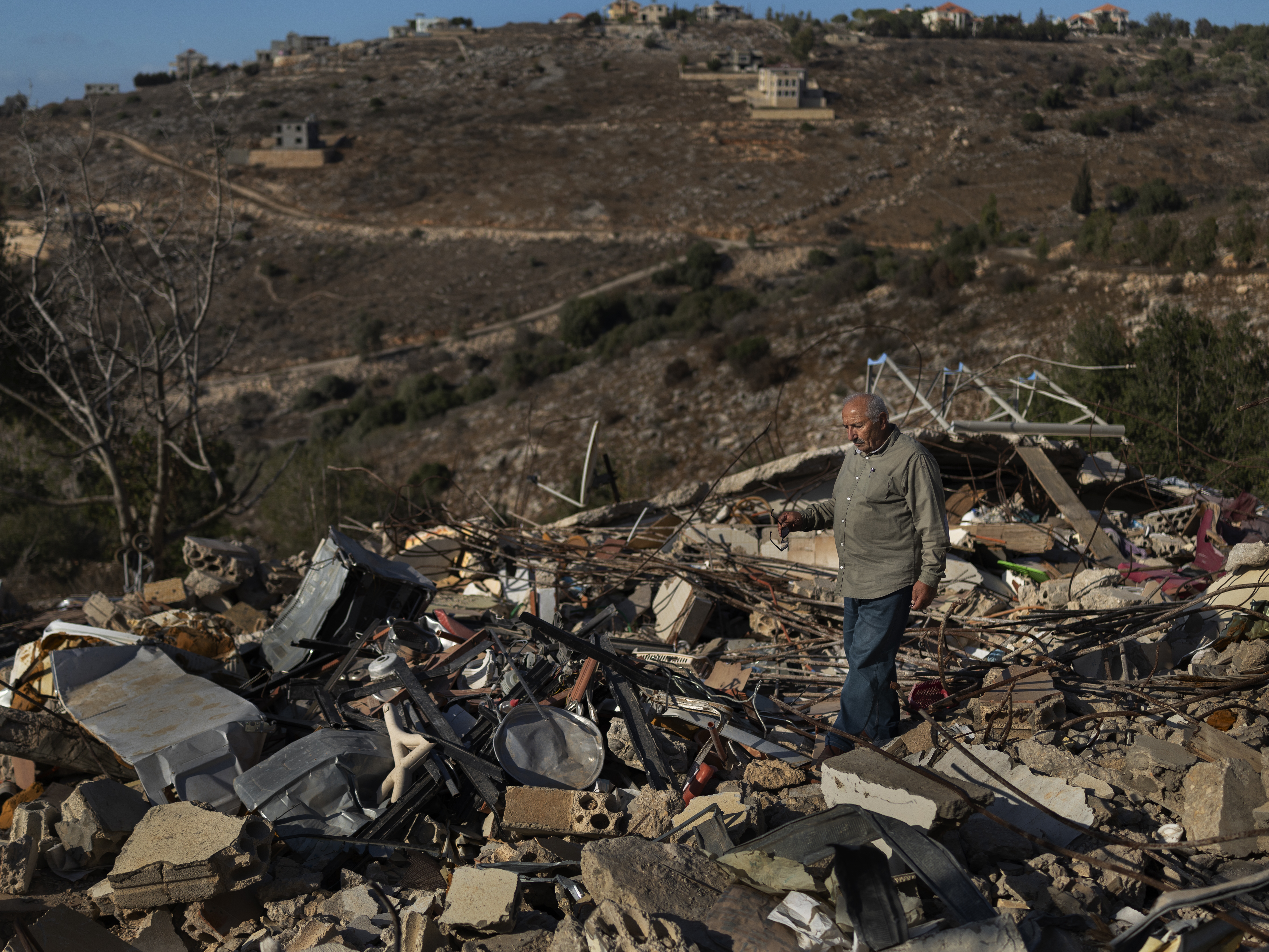 caption: Abdul Aziz Chreim at his destroyed home in Houla, Lebanon, on Sept. 26. His house, along with those of his relatives, was destroyed during the Israeli occupation following the ceasefire.