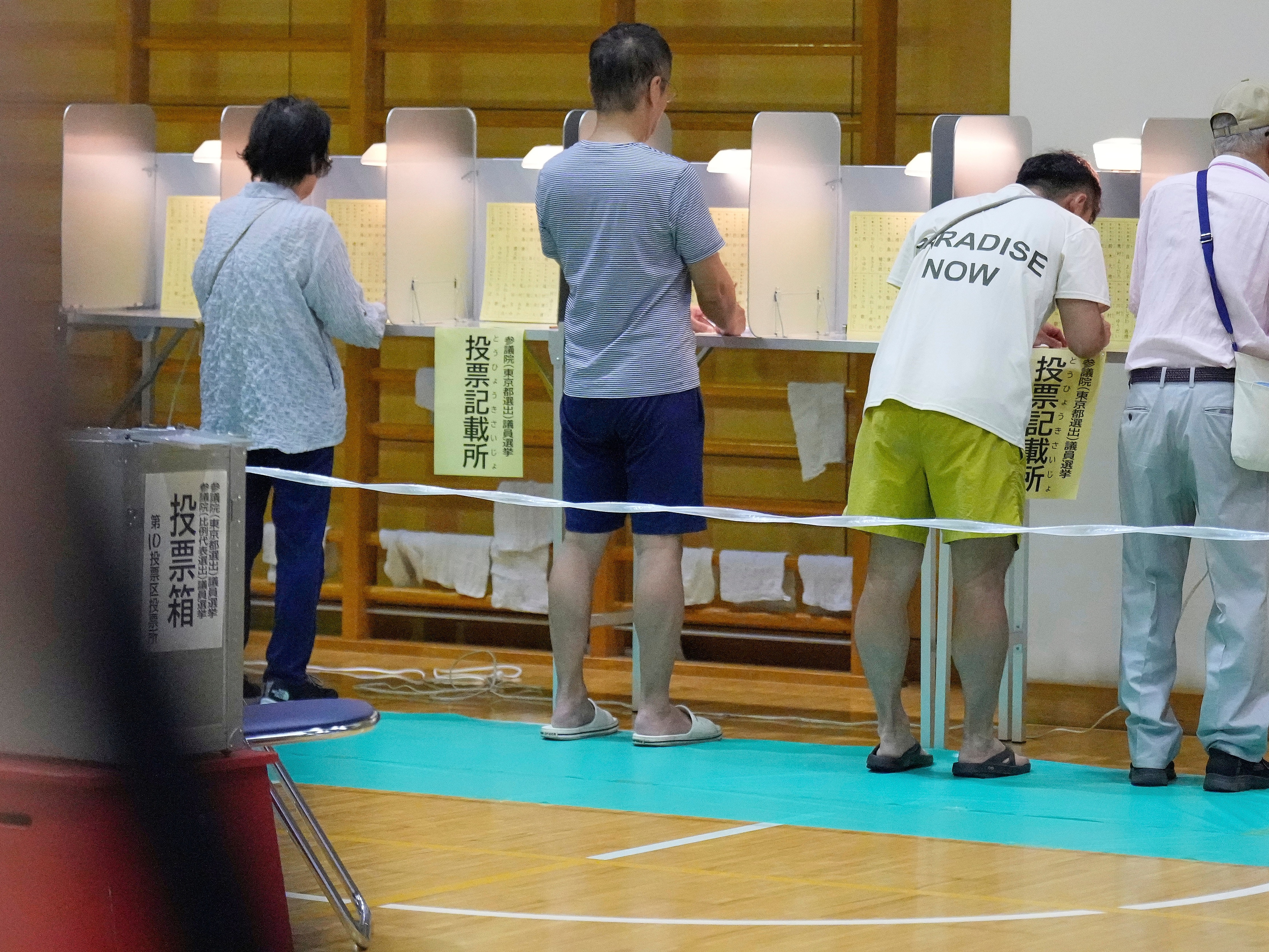 caption: Voters fill in their ballots in the upper house election at a polling station Sunday, July 20, 2025, in Tokyo.