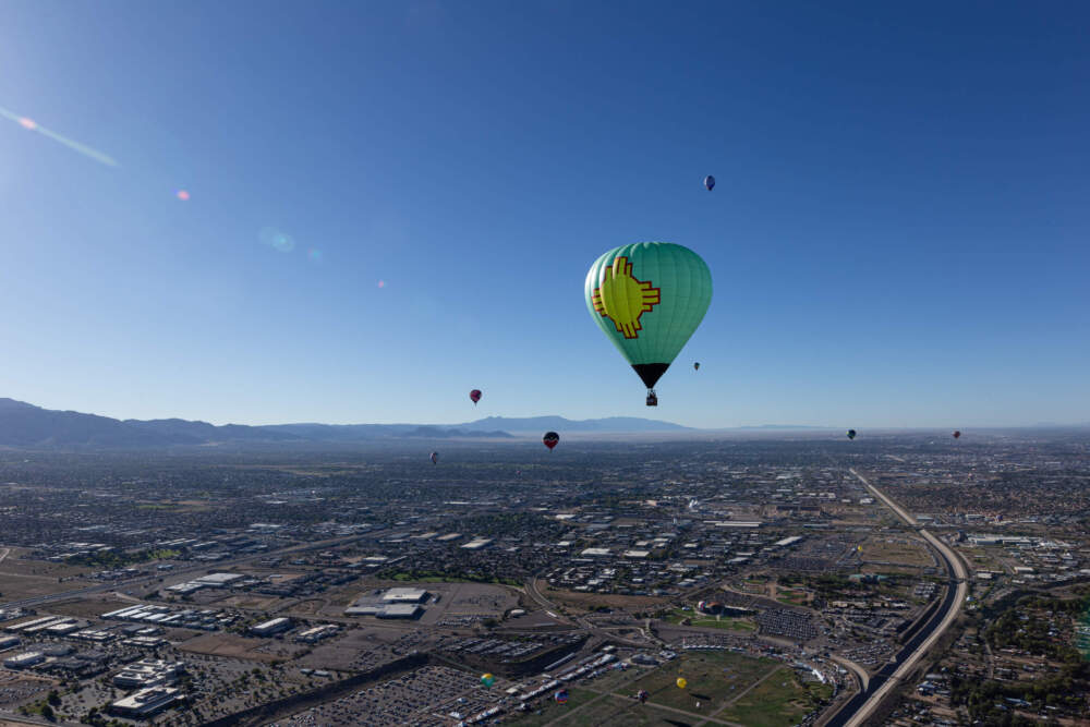 caption: Balloonists dot the Albuquerque sky over 1500 feet above ground level. Bryce Dix/KUNM)
