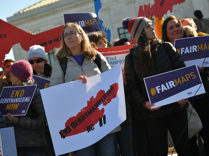caption: People rally in front of the Supreme Court on March 26 as the court hears arguments in redistricting cases. The court ruled that partisan redistricting is a political question, not one that federal courts can weigh in on.