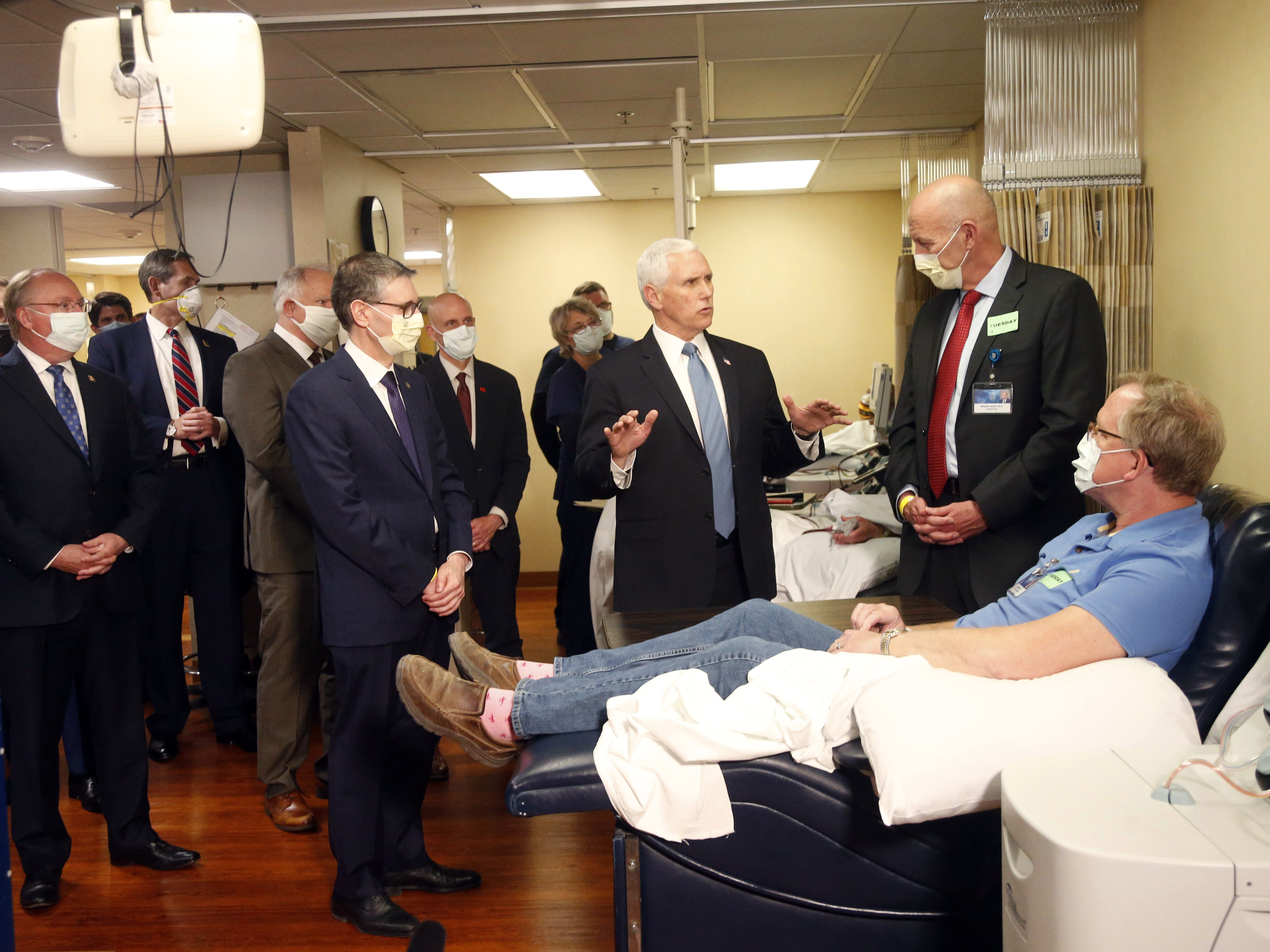caption: Vice President Pence visits with coronavirus survivor Dennis Nelson at the Mayo Clinic in Rochester, Minn., during a tour of facilities supporting COVID-19 research and treatment Tuesday.