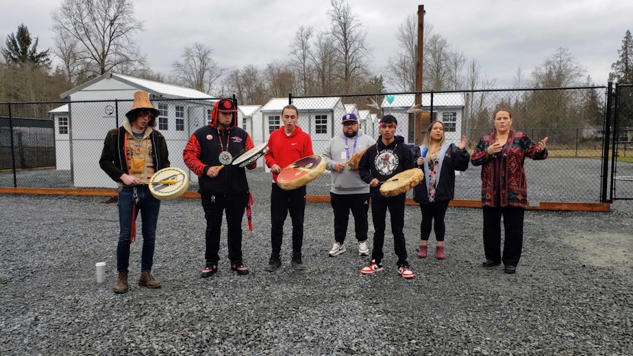 caption: Members of the Tulalip Tribes perform a blessing ceremony at the opening of the new village on Monday, Feb. 6, 2023. 