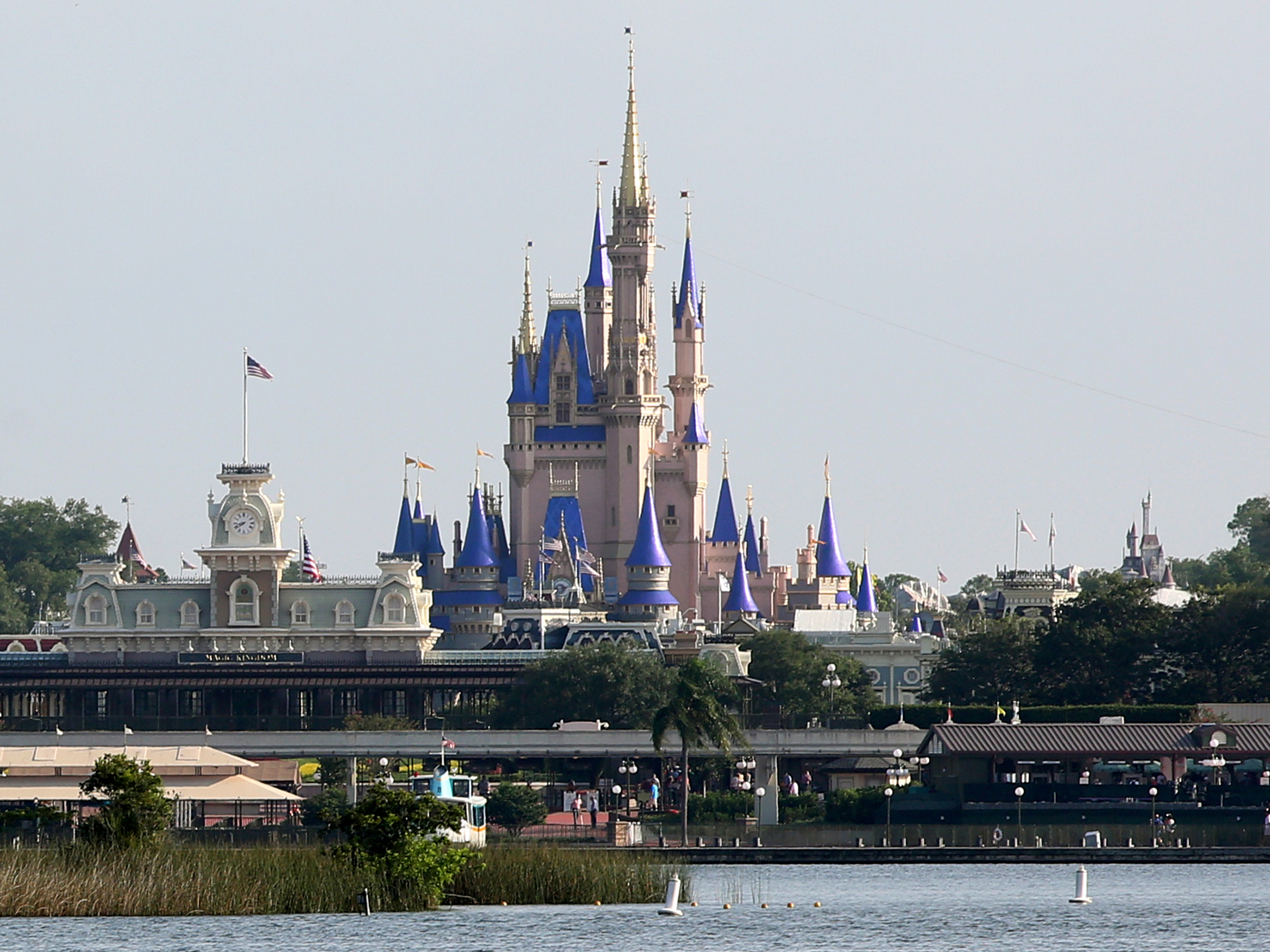 caption: Cinderella Castle rises above Bay Lake at the Magic Kingdom at Walt Disney World on Saturday. Disney reopened two of its Florida parks after nearly four months of being closed due to the pandemic.