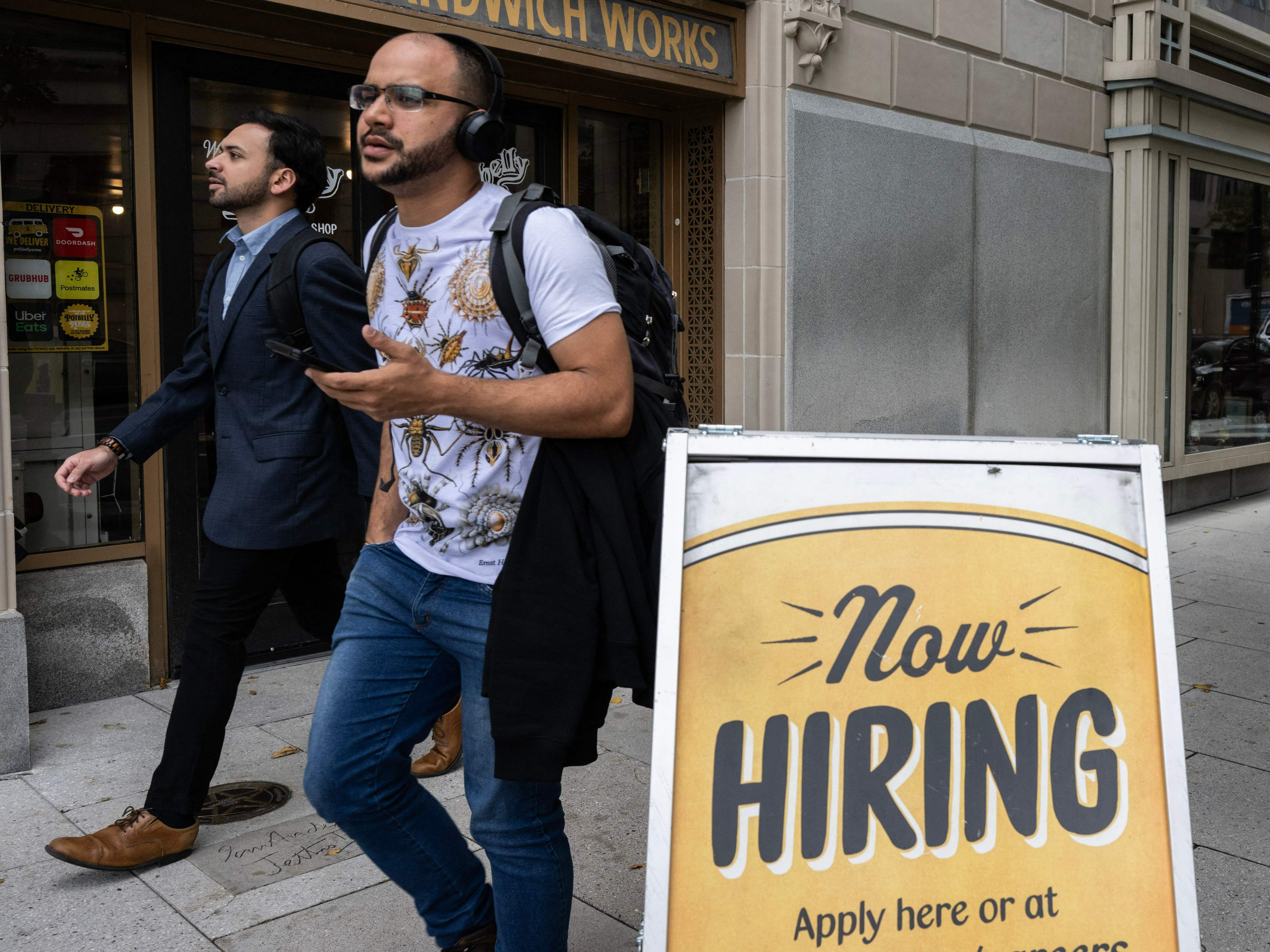 caption: People walk past a restaurant, with a hiring sign outside in Washington, D.C., on Oct. 5, 2023. Employers added 336,000 jobs in September, far more than what analysts had predicted.