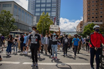 caption: Trey Rudolph leads an Eastside Change Coalition march through Bellevue this summer.