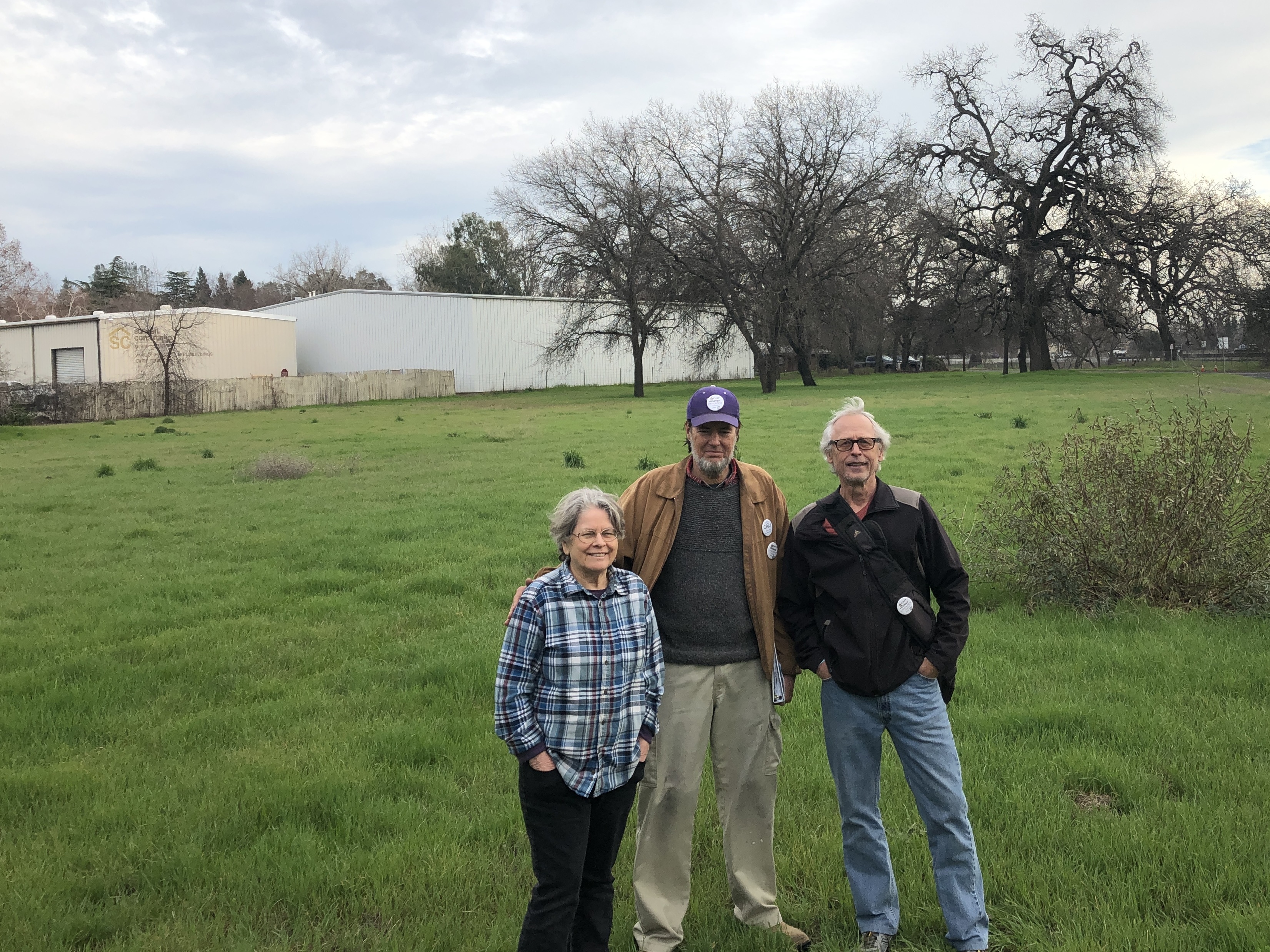 caption: Chico Housing Action Team organizers Leslie Johnson, left, Charles Withuhn, center, and Bill Kurnizki, right, in the field in south Chico where they plan to soon break ground on a 33-unit tiny home community for homeless adults called Simplicity Village.