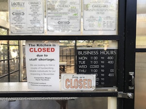 caption: A sign indicates that The Kitchen, a restaurant in Eastsound, is closed due to a staff shortage, on Saturday, September 25, 2021, on Orcas Island. 