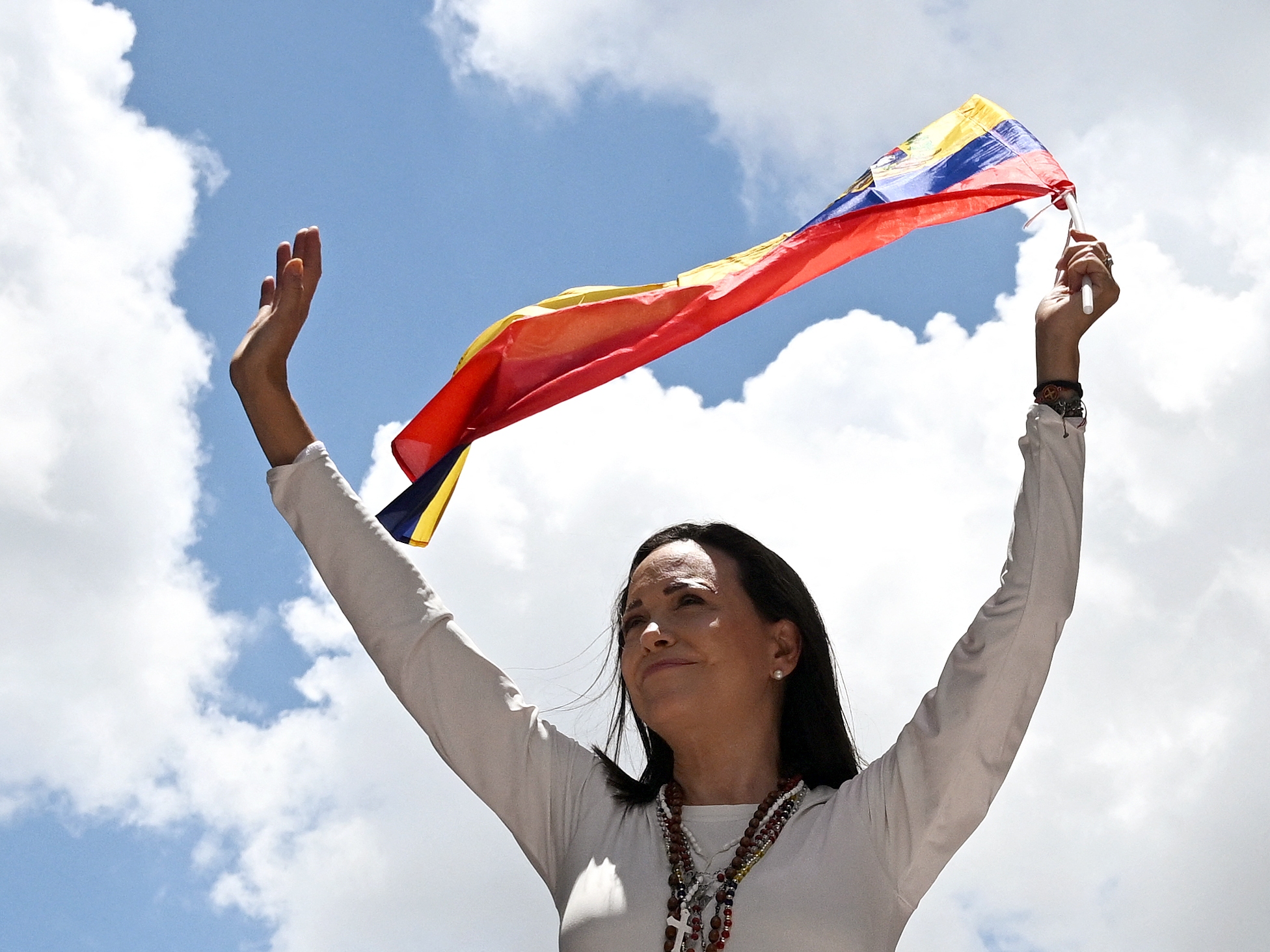 caption: Venezuelan opposition leader Maria Corina Machado waves a Venezuelan flag during a rally in Caracas on August 28, 2024.