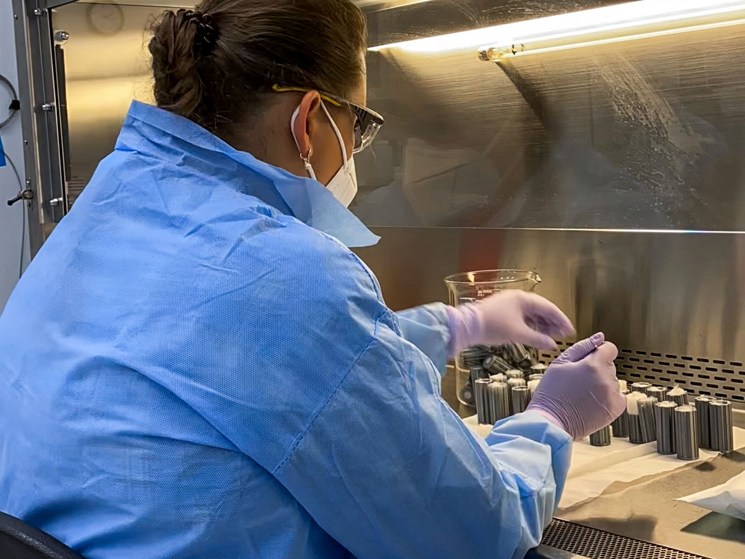 caption: Pacific Northwest National Laboratory staff technician Yuliya Farris prepares sterile spaces used to hold soil in place for an experiment dubbed the Dynamics of the Microbiome in Space, known as DynaMoS. A SpaceX resupply mission will transport soil samples to the International Space Station, likely June 10.