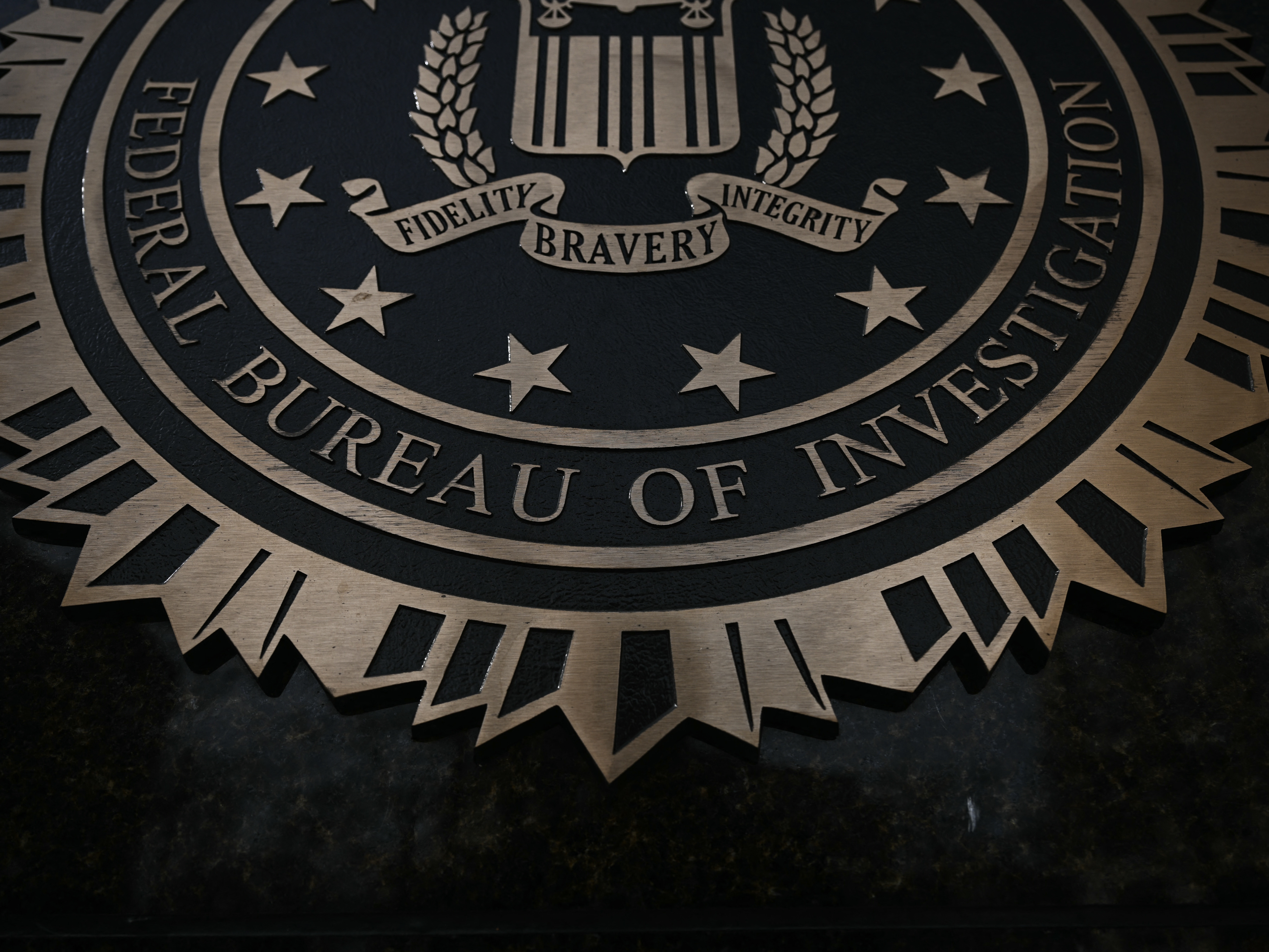 caption: The J. Edgar Hoover building's FBI seal pictured in March in Washington, D.C. Dan Bongino, deputy director of the FBI, announced the bureau's renewed efforts around three cases on Monday.