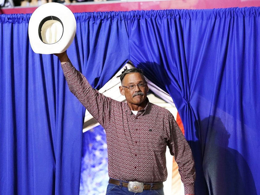 caption: Mark Finchem, a Republican candidate for Arizona secretary of state, waves to the crowd as he arrives to speak at a rally put on by former President Donald Trump in Arizona on July 22.