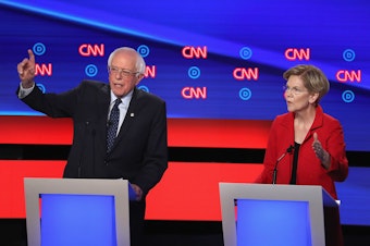 caption: Democratic presidential candidates Bernie Sanders and Elizabeth Warren say corporate America has put profits before workers by shifting jobs to other countries.