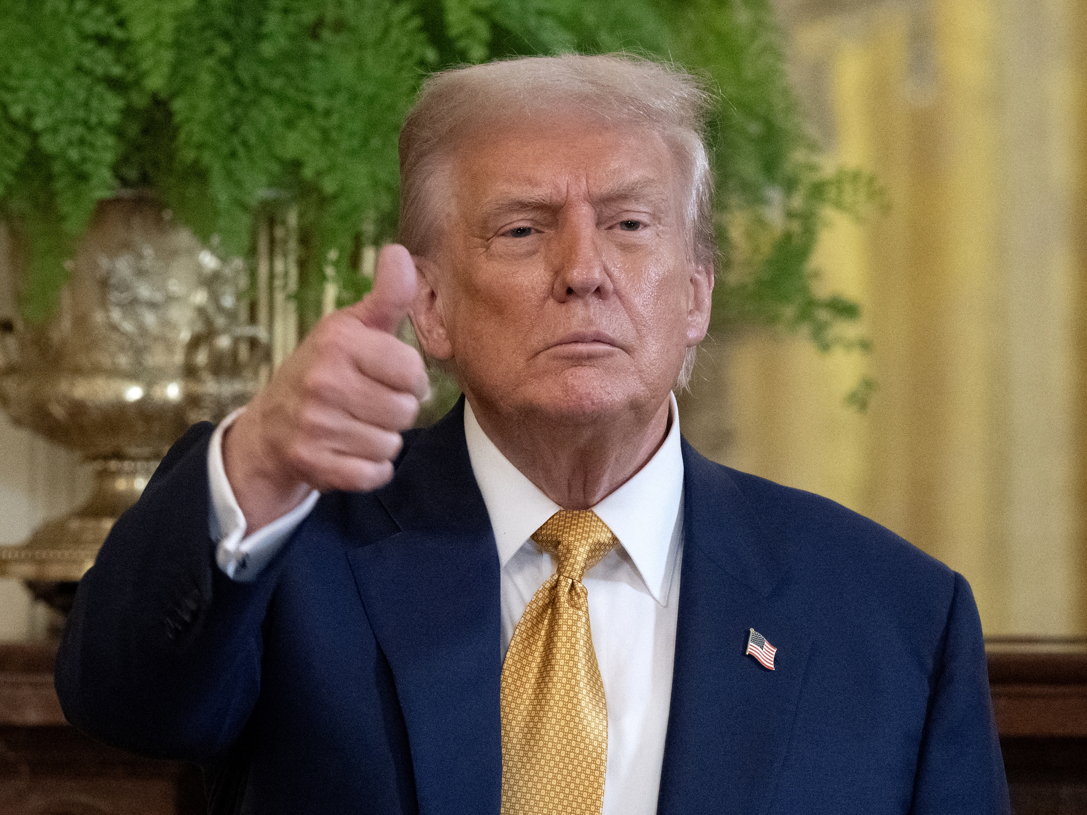 caption: President Trump gestures to the press at the end of a reception with Republican members of Congress at the White House on July 22, 2025.
