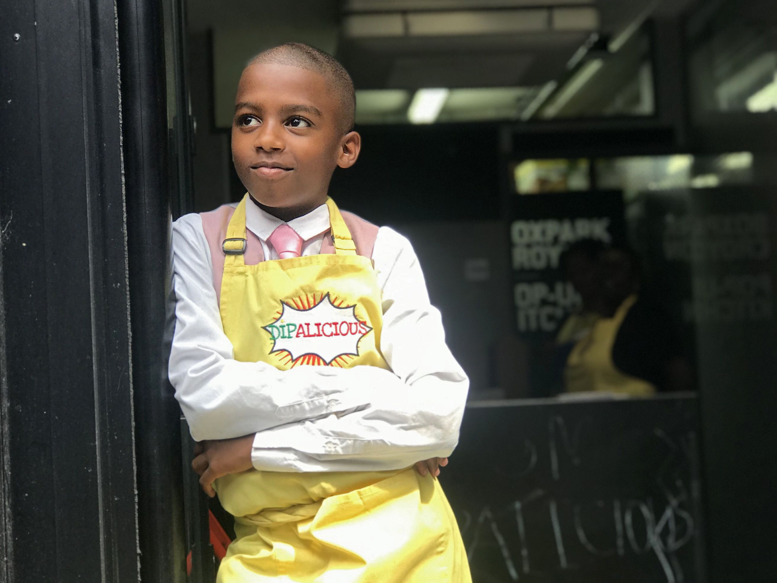 caption: Chef Omari McQueen stands in the doorway of his vegan Caribbean pop-up restaurant Dipalicious.