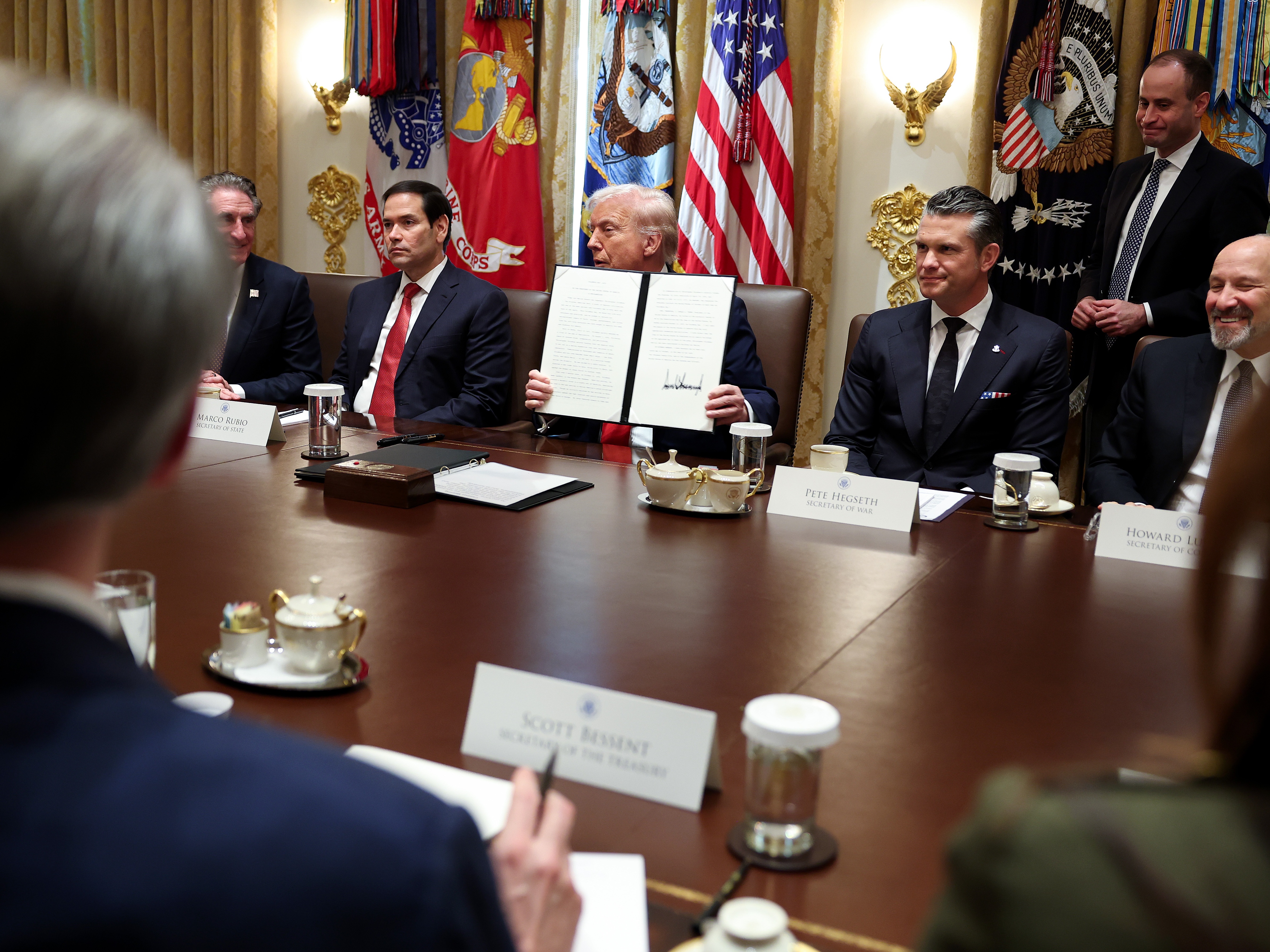 caption: President Trump holds up a presidential proclamation for Columbus Day during a Cabinet meeting at the White House on Thursday.