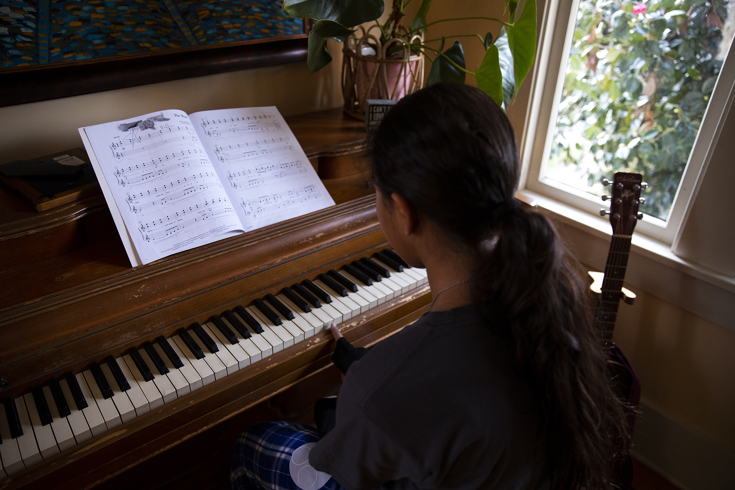 caption: Alejandra’s 11-year-old daughter practices the piano after school on Friday, January 23, 2026, at Karina’s home in Seattle. 