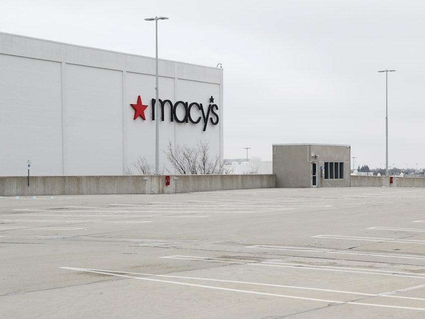 caption: An empty parking lot surrounds the Macy's at the Roosevelt Field Mall on March 20 in East Garden City, N.Y. The retail chain had previously announced plans to close about 125 stores over the next three years.