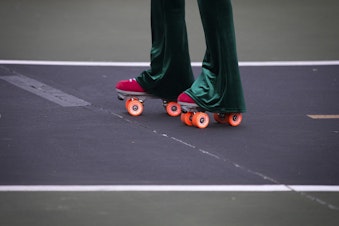 caption: Vanessa Poston roller-skates during a decades themed skate meet up on Tuesday, October 6, 2020, at the White Center Bicycle Playground in Seattle.