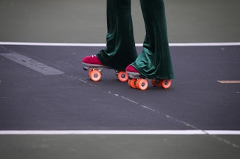 caption: Vanessa Poston roller-skates during a decades themed skate meet up on Tuesday, October 6, 2020, at the White Center Bicycle Playground in Seattle.