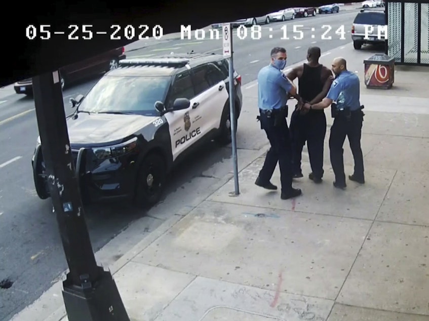 caption: This image from video shows Minneapolis police officers Thomas Lane, left, and J. Alexander Kueng, right, escorting George Floyd, center, to a police vehicle outside Cup Foods in Minneapolis, on May 25, 2020. The image was shown as prosecutor Steve Schleicher gave closing arguments in the trial of Derek Chauvin for the death of Floyd.