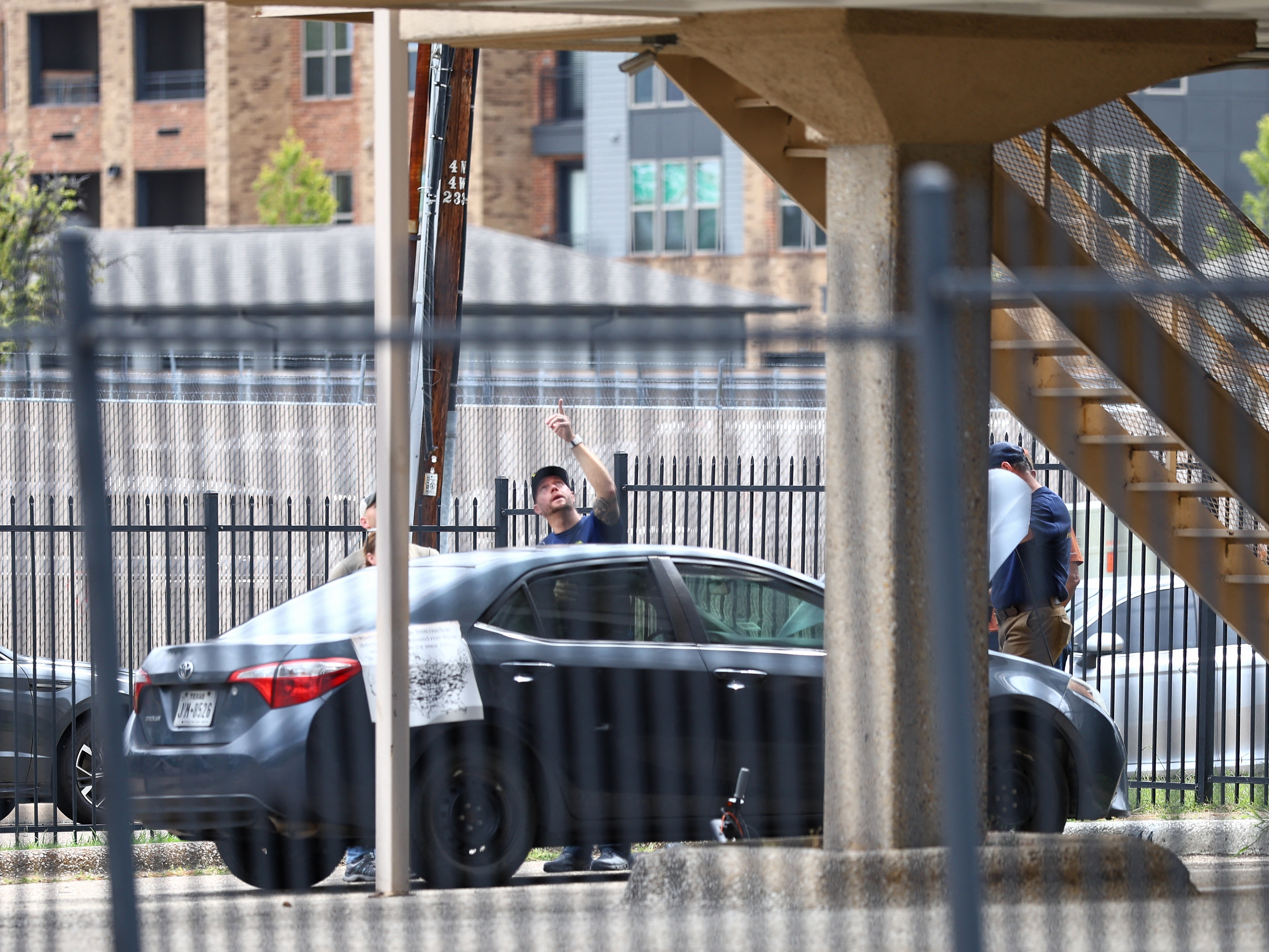 caption: FBI and other law enforcement officials investigate a vehicle parked near the building allegedly used by the gunman who perpetrated a shooting near an Immigration and Customs Enforcement facility in Dallas on Wednesday.