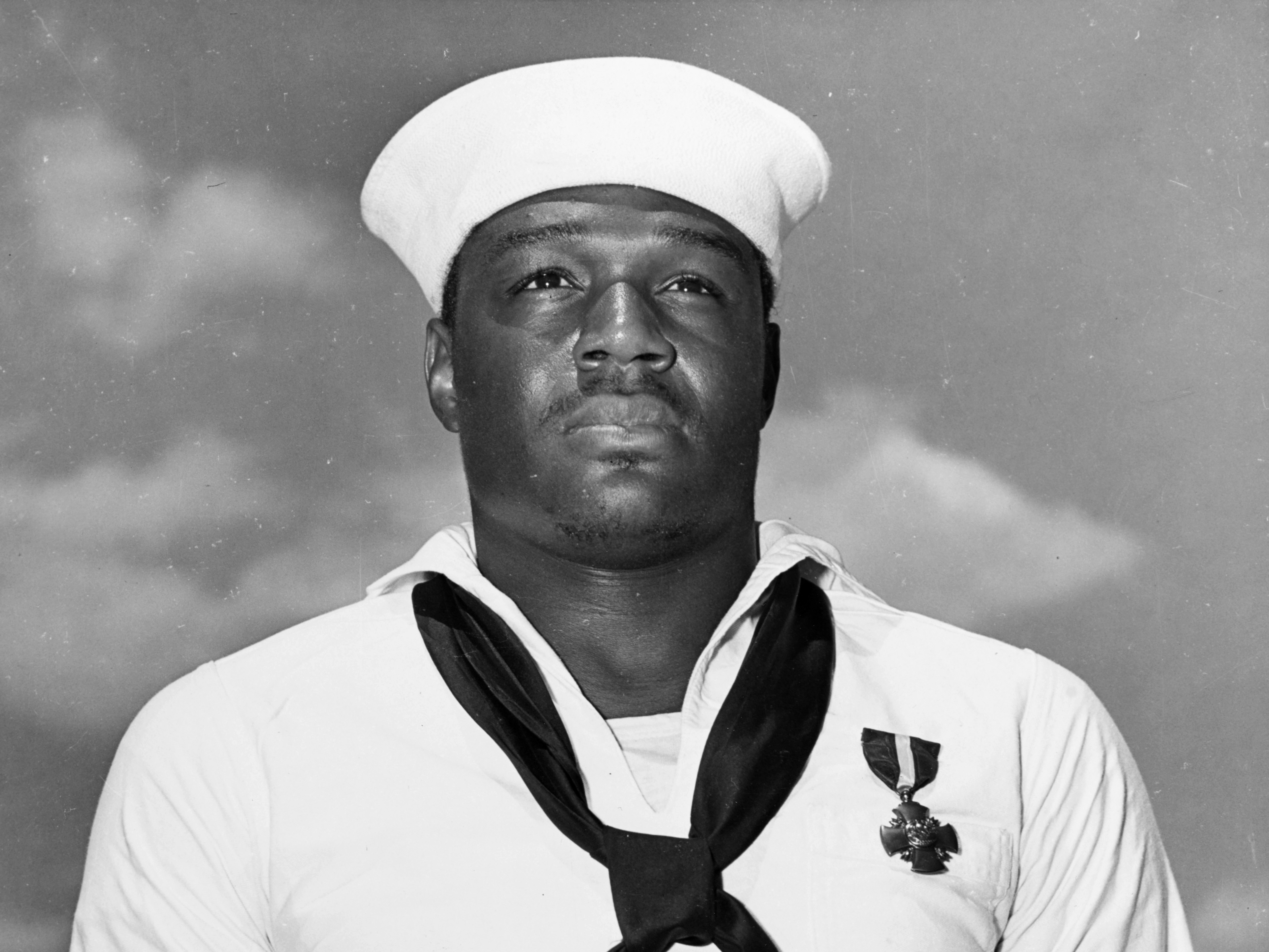 caption: In this photo taken May 27, 1942, Mess Attendant 2nd Class Doris Miller stands at attention after being awarded the Navy Cross for for his actions aboard the USS West Virginia during the Japanese attack on Pearl Harbor on Dec. 7, 1941.
