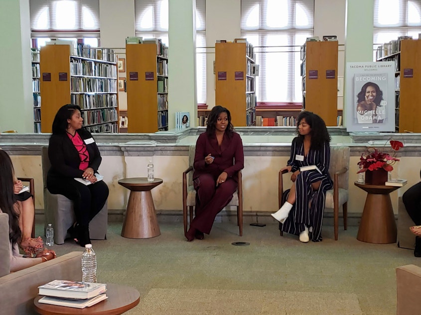 caption: Former First Lady Michelle Obama meets with the Balanced Black Girl Book Club at the Tacoma Public Library on Sunday, March 24, 2019.