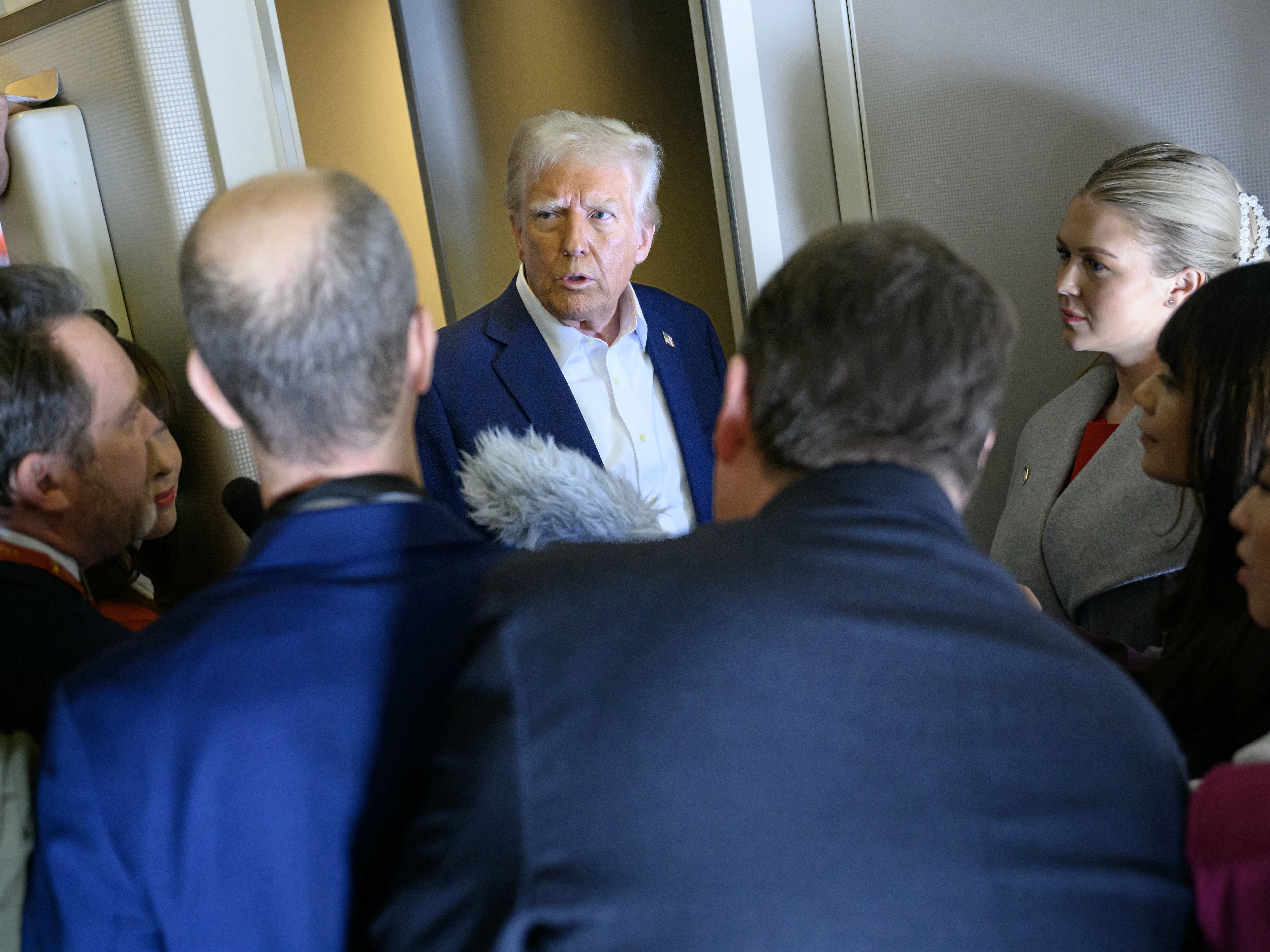 caption: President Donald Trump speaks with the press aboard Air Force One en route to Miami on Saturday.