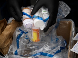 caption: Containers of pills and prescription drugs are boxed for disposal during the Drug Enforcement Administration's 20th National Prescription Drug Take Back Day on April 24, 2021. Nearly 108,000 people died in 2021 from drug overdoses.