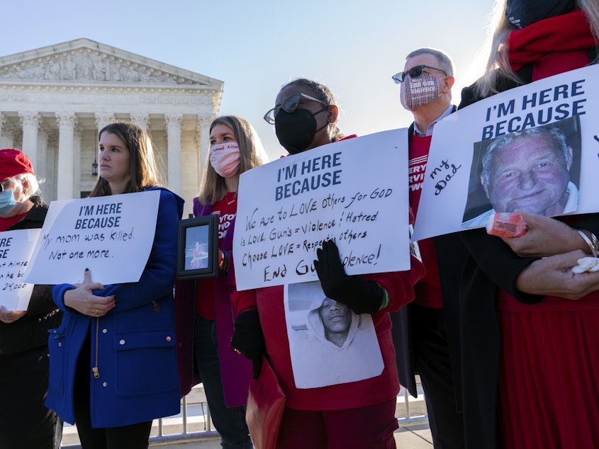 caption: Gun violence survivors hold their banners during a rally Wednesday outside of the U.S. Supreme Court. The court heard arguments in a gun rights case that centers on New York's restrictive gun permit law.