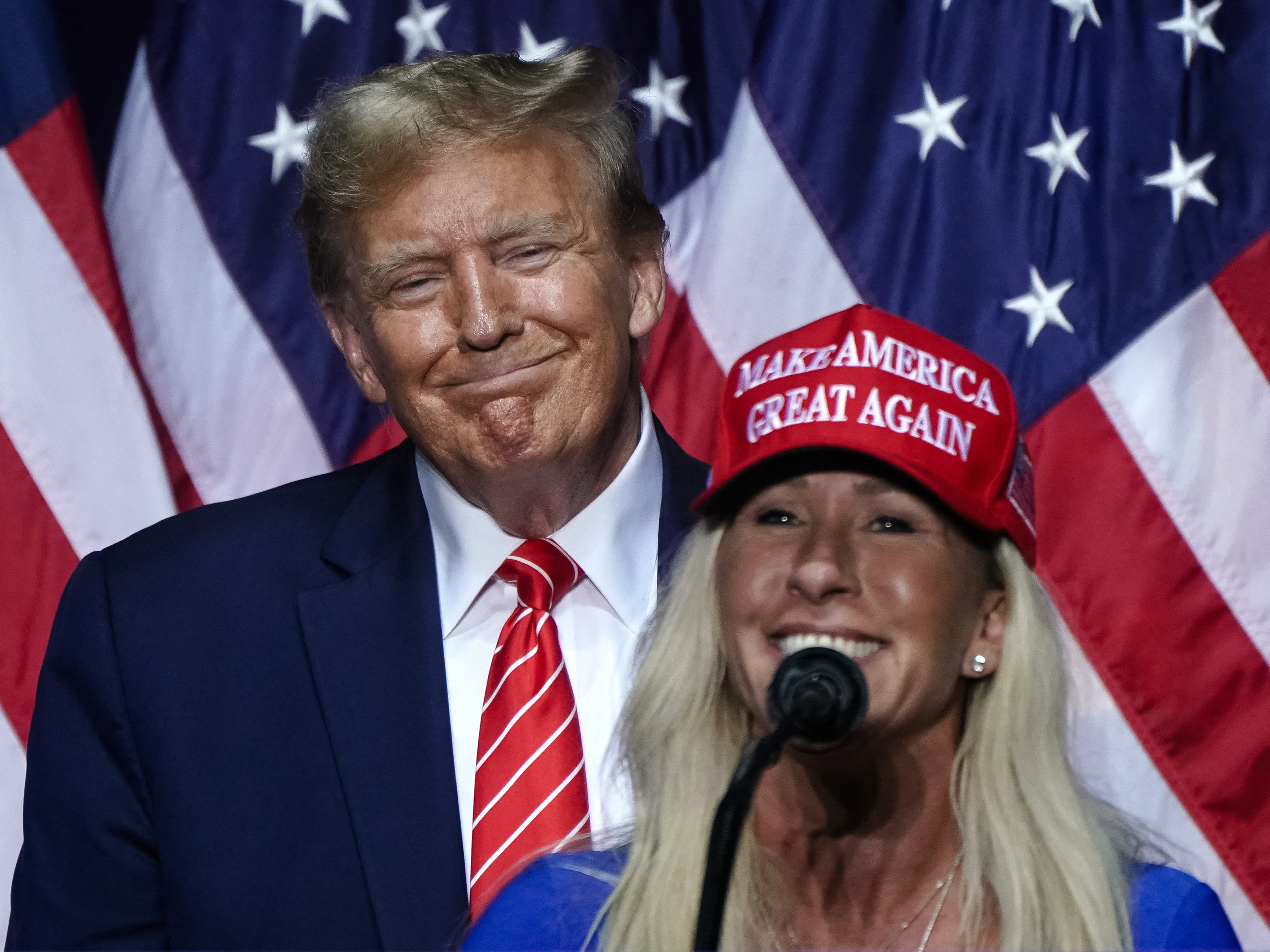 caption: In this file photo, Rep. Marjorie Taylor Greene (R) speaks alongside President Trump at a campaign event  when he was a presidential candidate, in Rome, Georgia, on March 9, 2024.