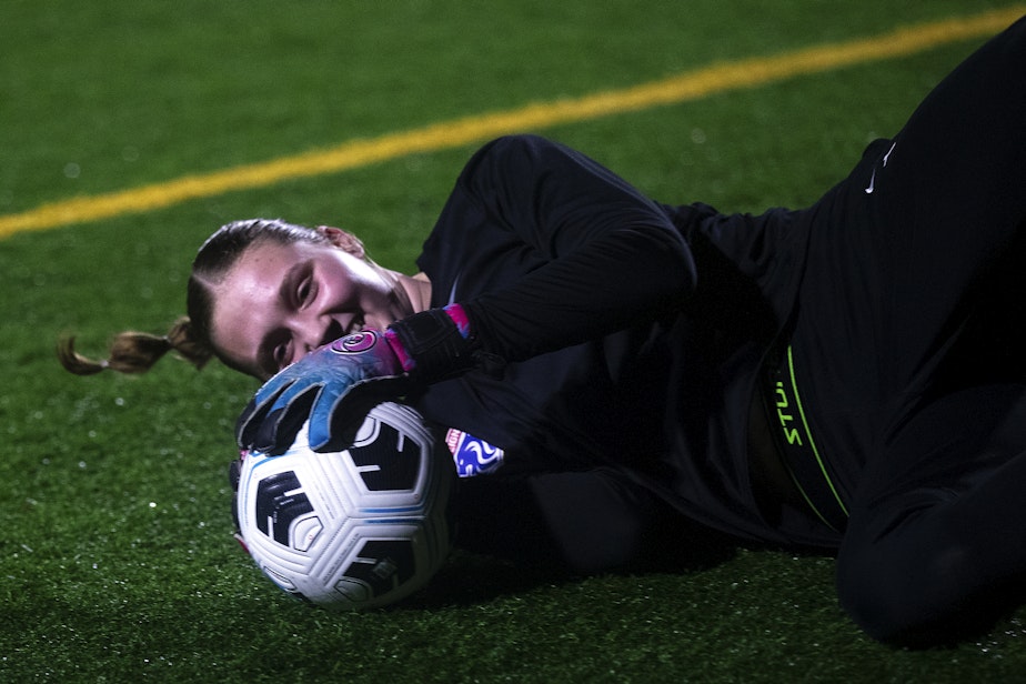 caption: Tyler Roberts, 15, laughs while diving for the soccer ball during goal keeper training with Seattle Reign Academy on Monday, January 29, 2024, at North SeaTac Park.