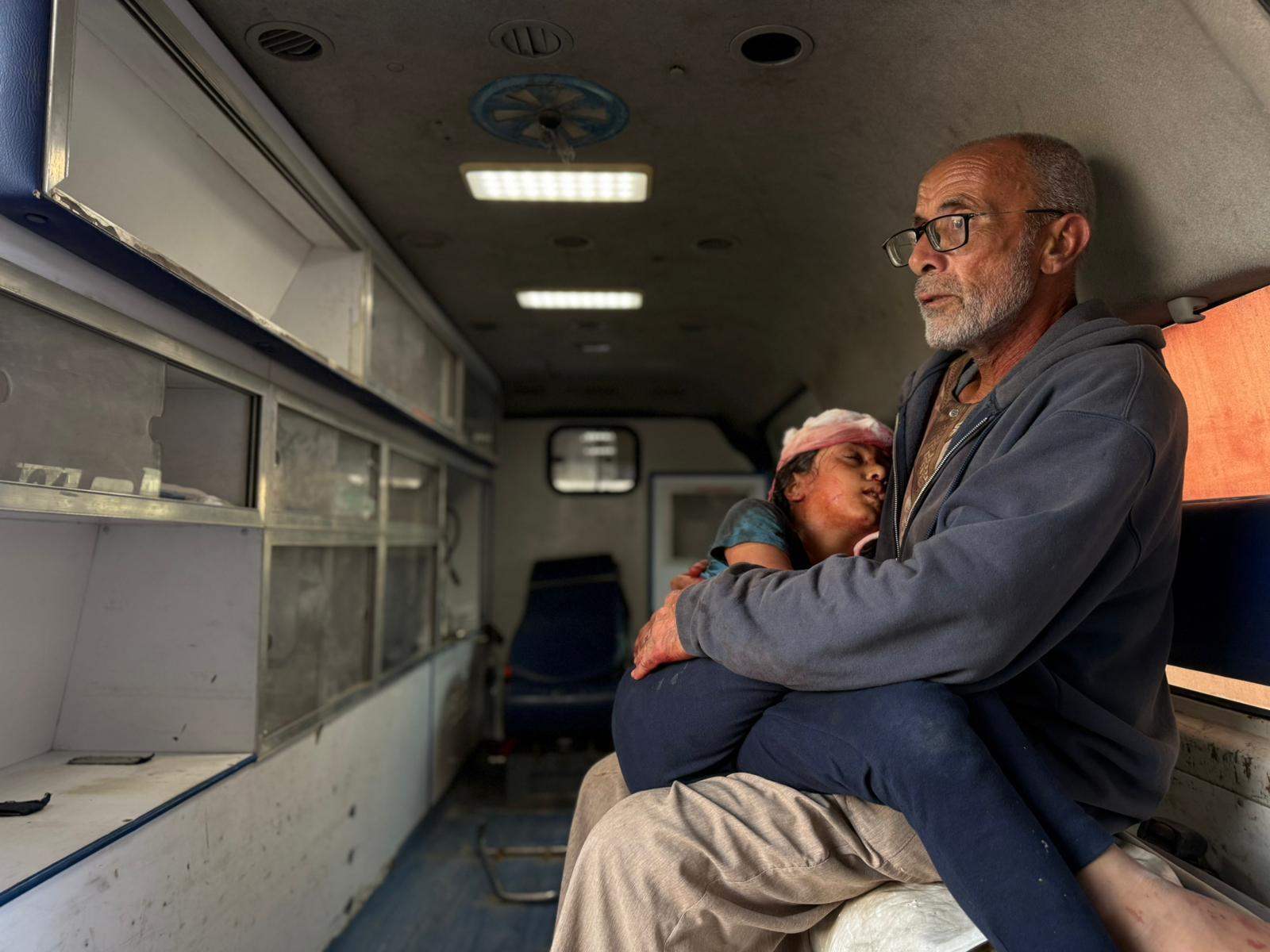 caption: Saqer al-Ankah holds his 10-year-old granddaughter, Bayan al-Ankah, after he says she was shot in the head by Israeli forces in northern Gaza about half a mile from the so-called yellow line on Dec. 10.