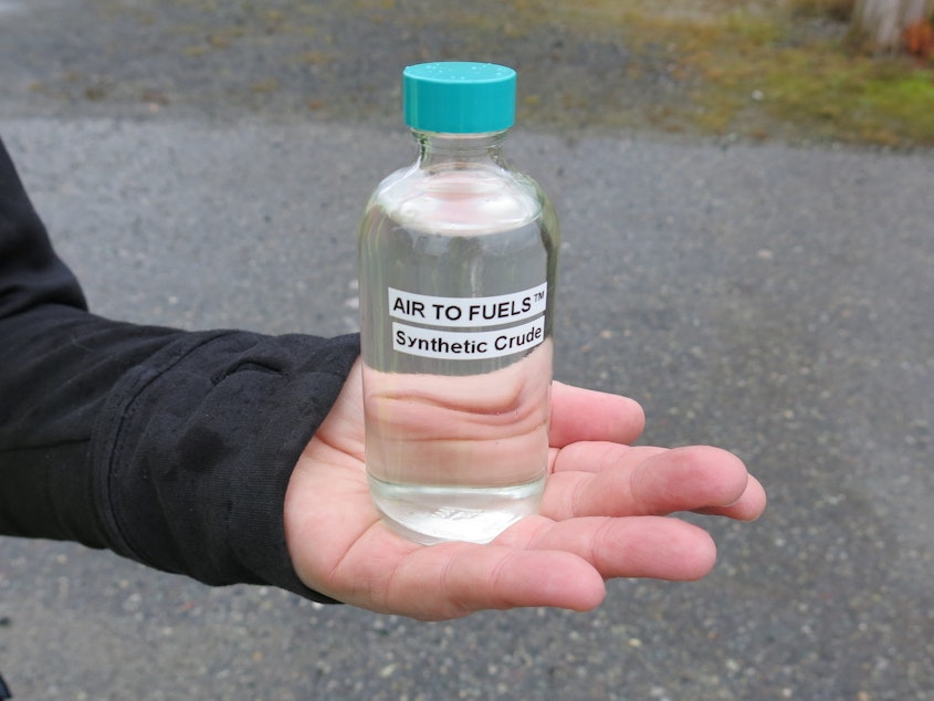 caption: McCahill holds a jar of synthetic fuel the company manufactured from carbon dioxide sucked out of the air and hydrogen extracted from water.