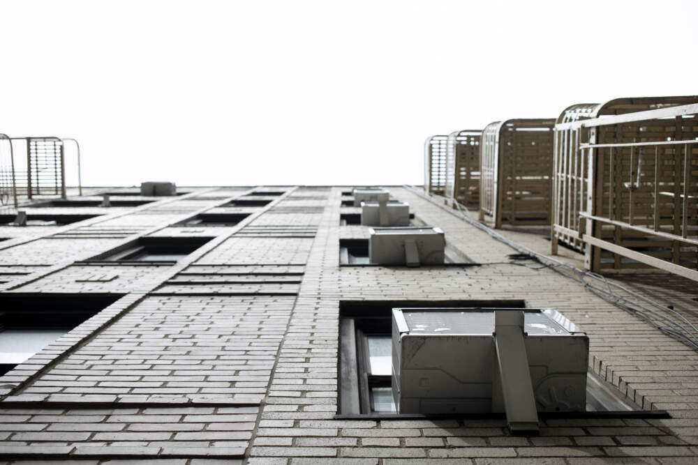 caption: Window air conditioning units sit in windows in New York. (Jenny Kane/AP)