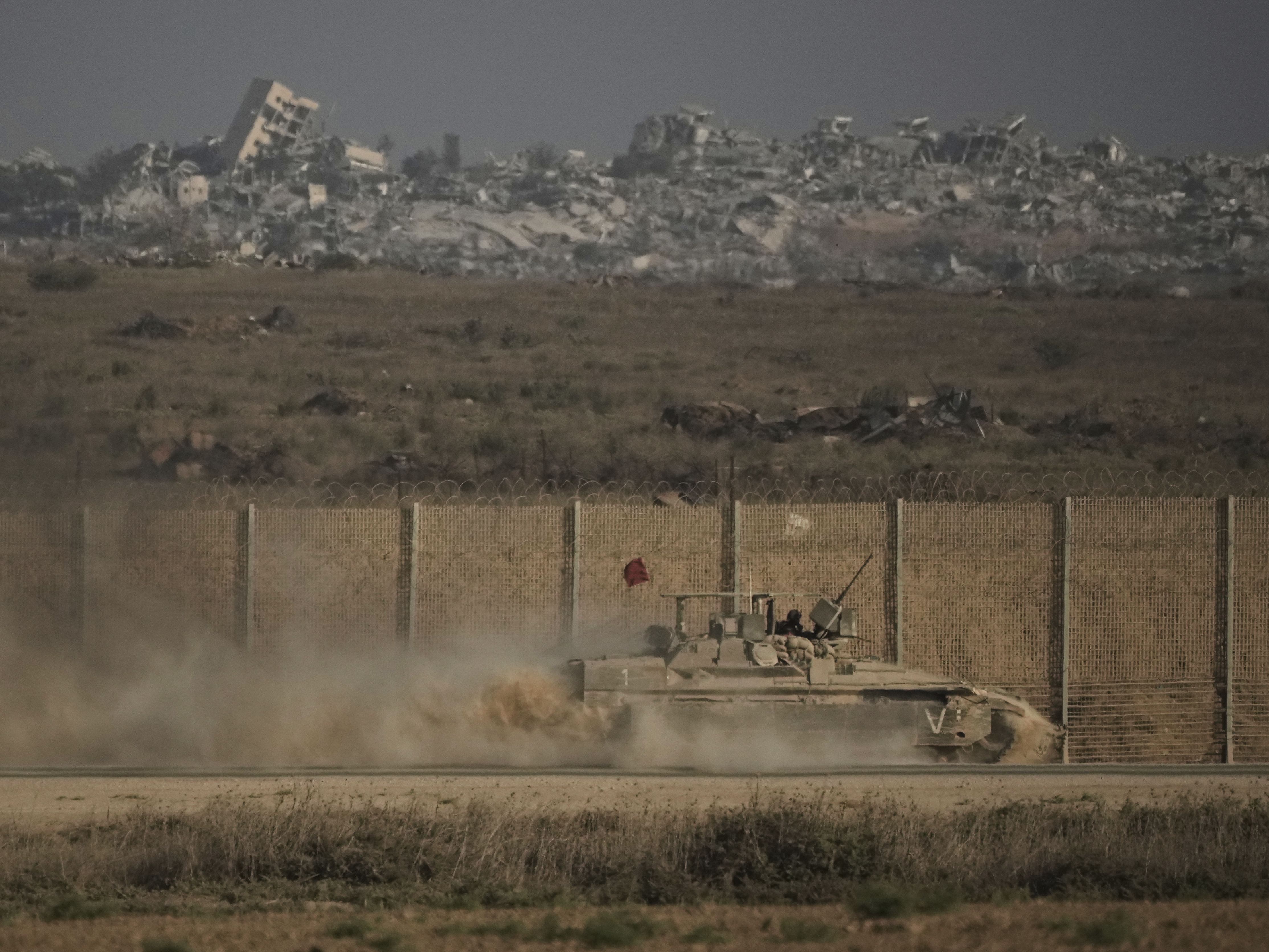 caption: An Israeli armored vehicle moves along the Israeli-Gaza border as seen from southern Israel, Tuesday, Sept. 16, 2025.