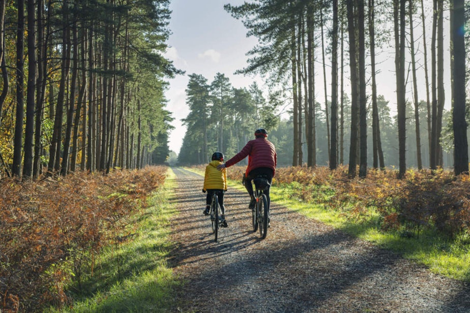 caption: A child and parent ride bikes together. (Justin Paget/Getty Images)