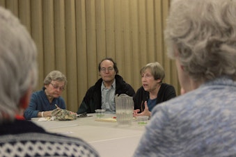 caption: Carin Mack (center right), a geriatric social worker, leads a discussion on avoiding loneliness, like volunteer work.