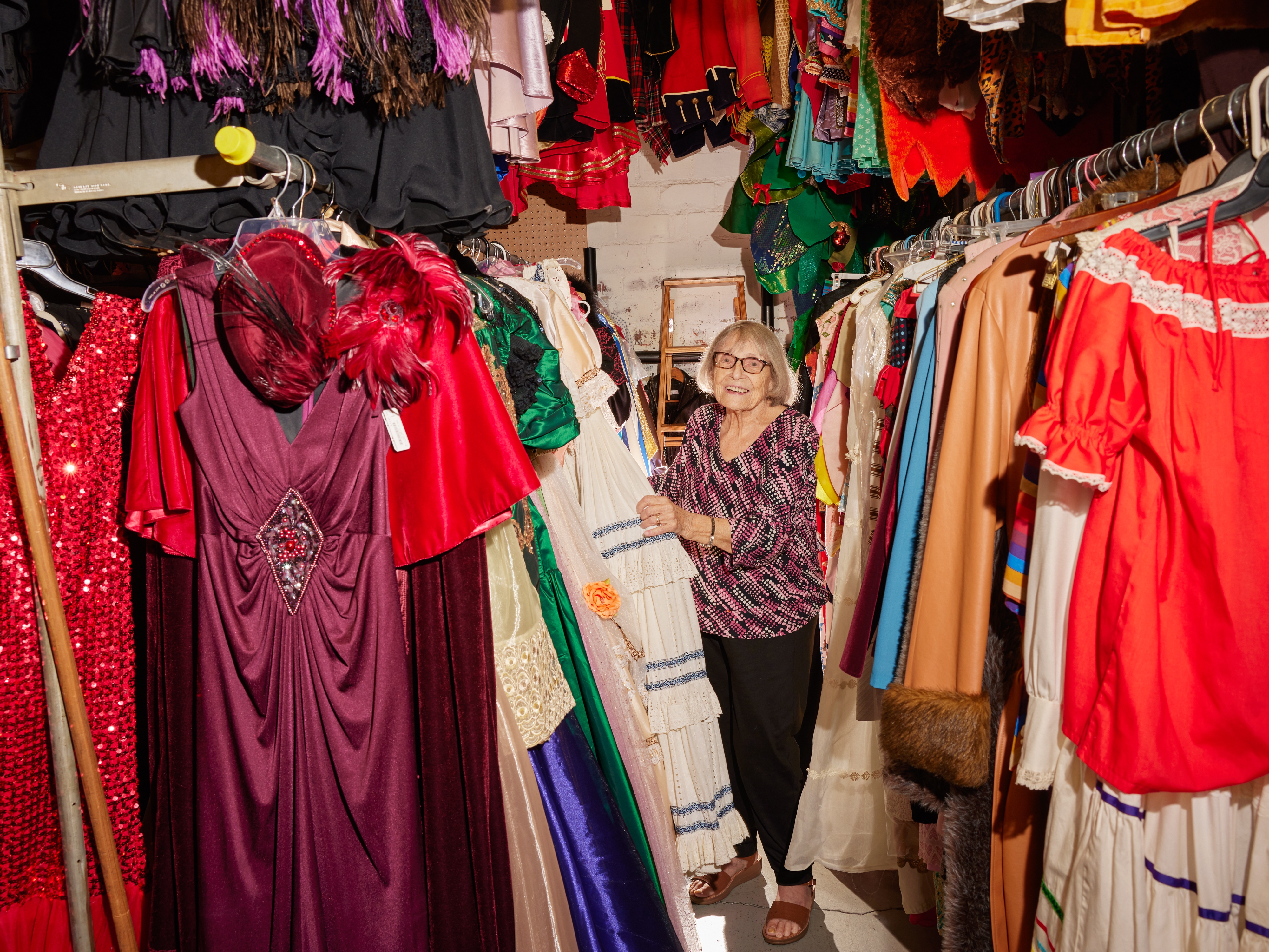 caption: Ursula Boschet, 90, owner of Ursula’s Costumes, browses through the handmade costumes in her shop.