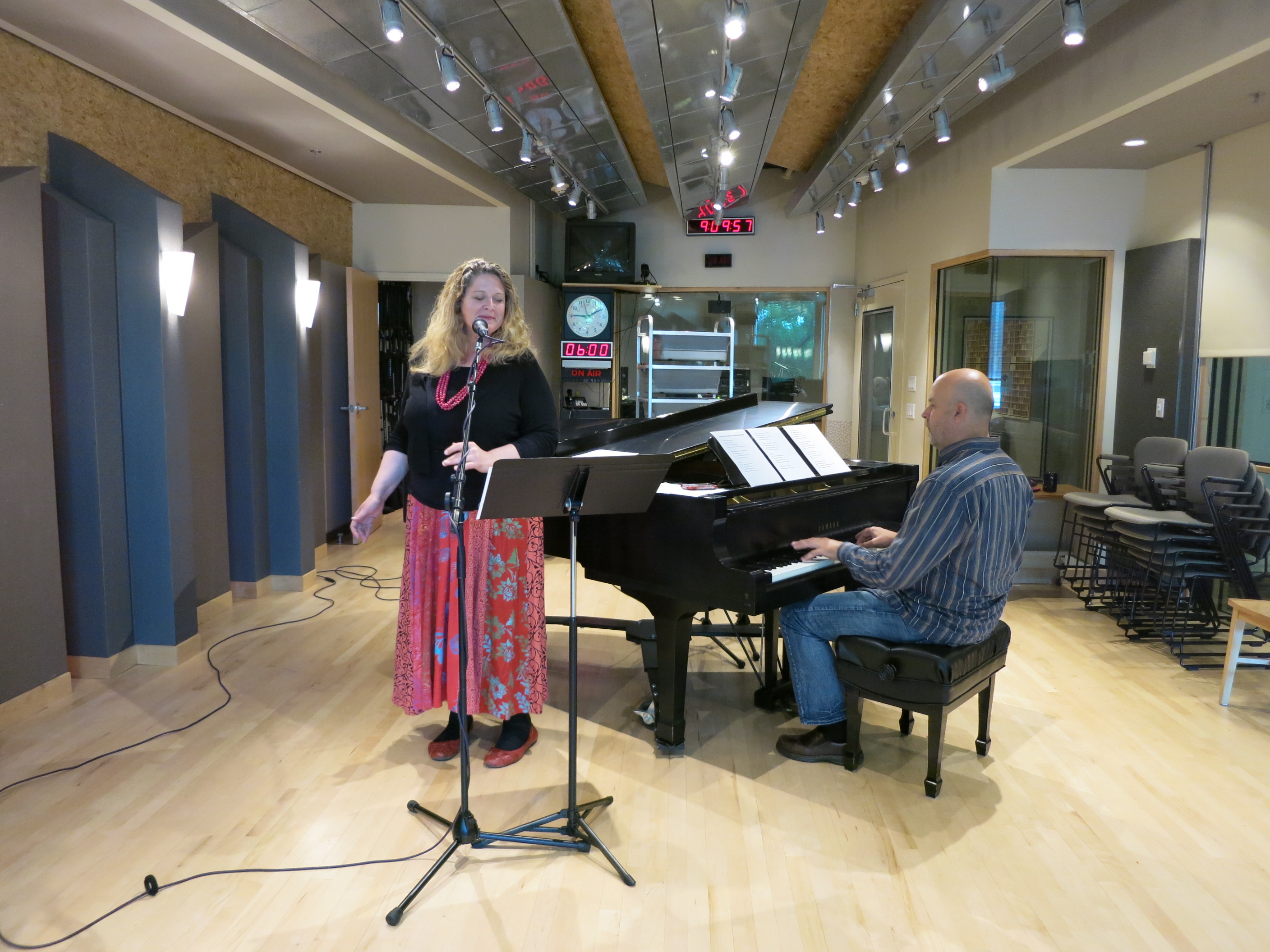 caption: Newscaster Lisa Brooks and announcer Guy Nelson perform "Seattle, The Peerless City" in KUOW's performance studio. 