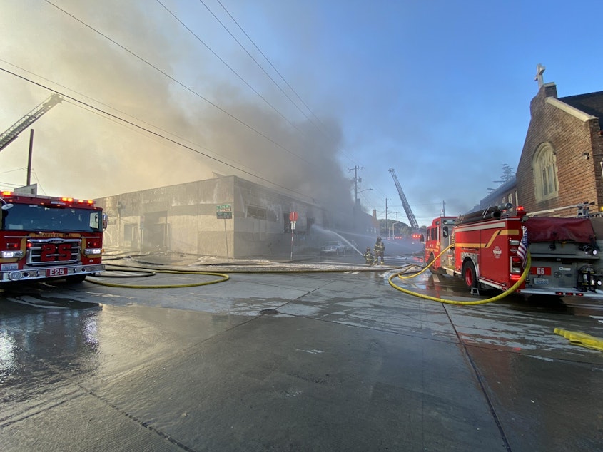 caption: Seattle fire crews respond to a two-alarm fire at a vacant warehouse in the 1000 block of South King Street on July 20, 2023. 