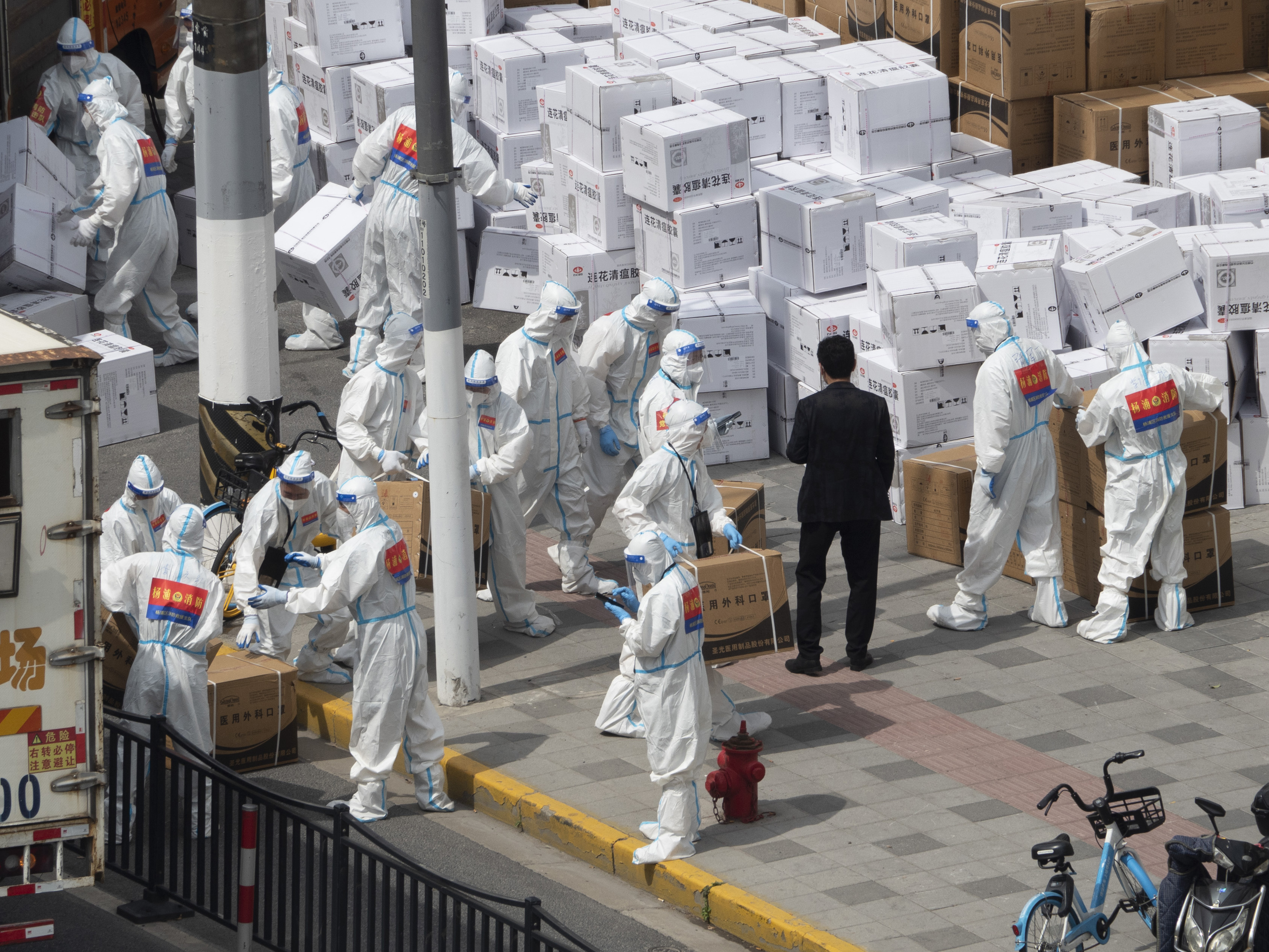 caption: Workers unload supplies including boxes of masks in Shanghai on Sunday, April 10, 2022.