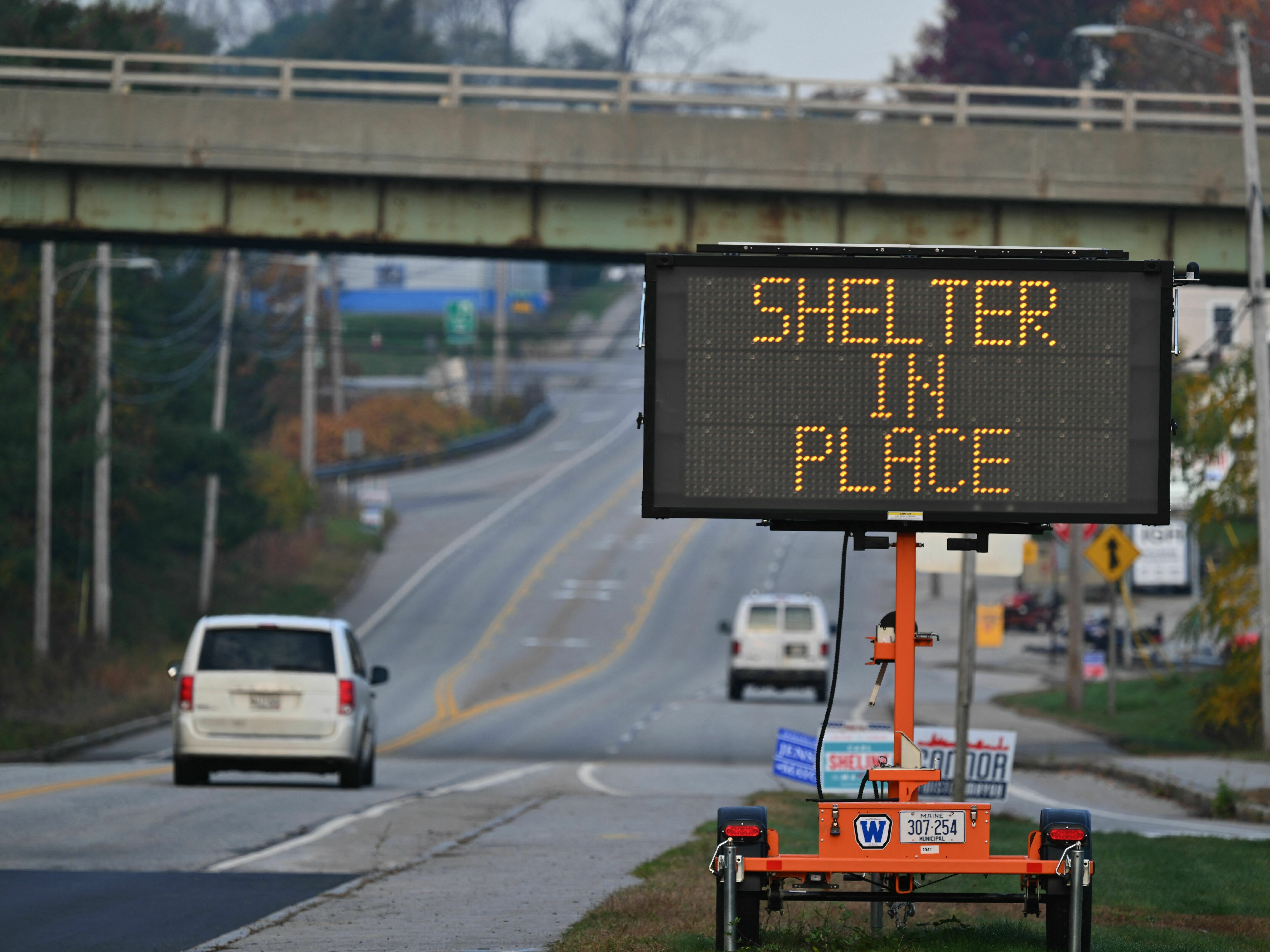 caption: A sign warns to shelter in place in Lewiston, Maine, on Friday in the aftermath of a mass shooting.