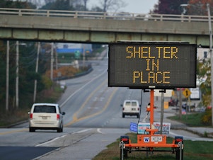 caption: A sign warns to shelter in place in Lewiston, Maine, on Friday in the aftermath of a mass shooting.